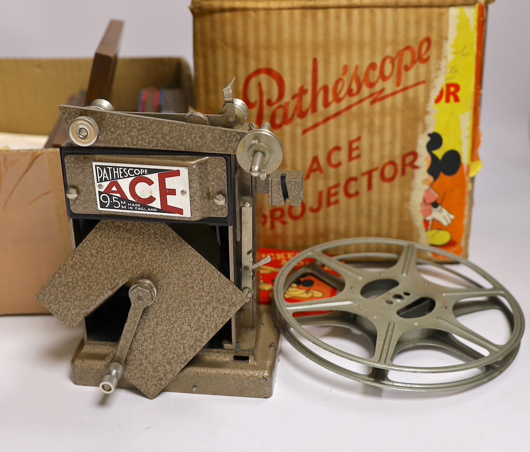 A collection of magic lantern slides, including some painted examples and some in frames, together with a 9.5mm Pathescope Ace Projector with five reels including a Disney Mickey Mouse reel, plus a few early 20th century